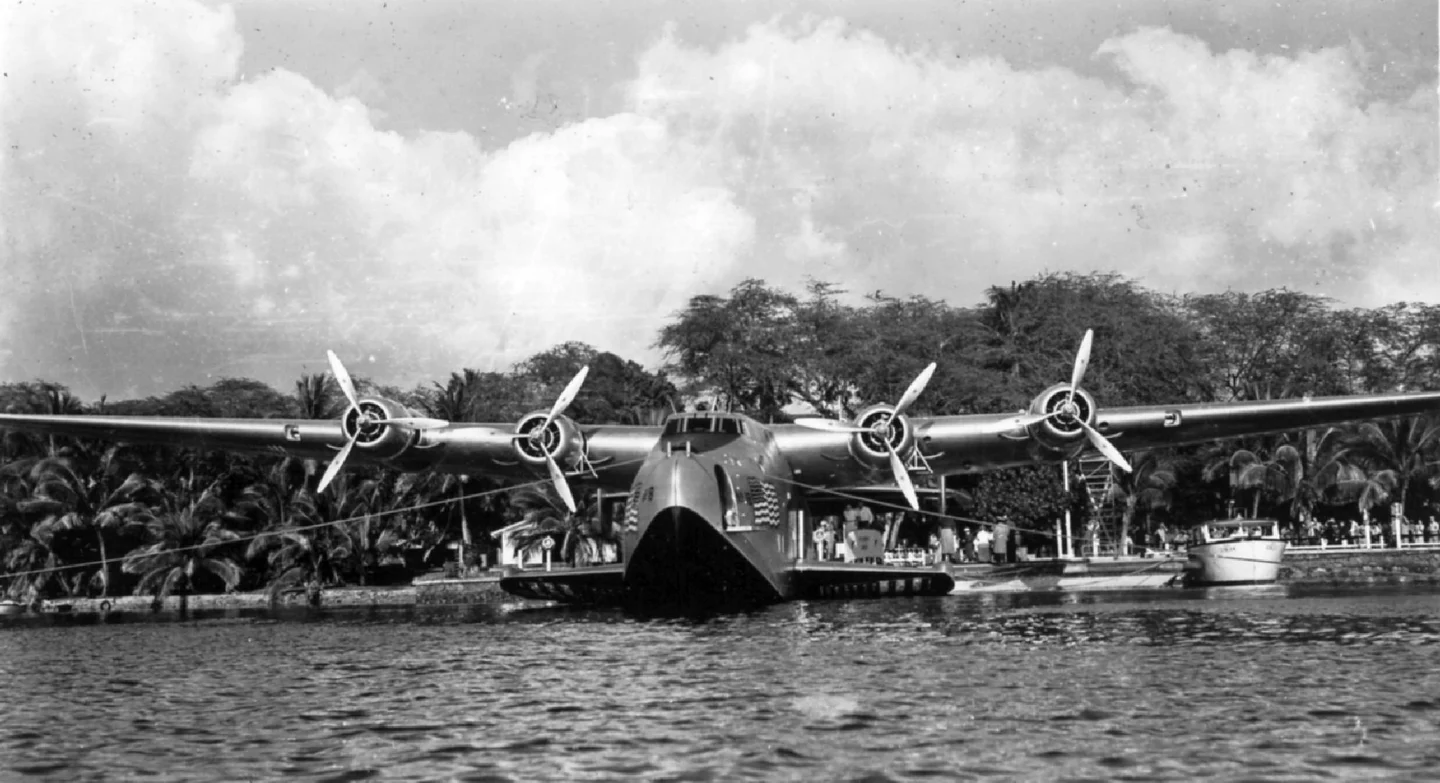 A four-engine Boeing 314 Clipper flying boat moored on the water.